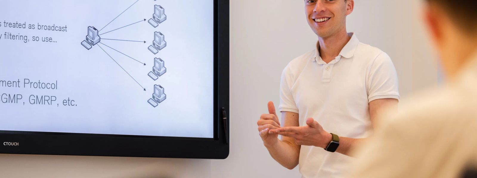 A trainer presenting a network diagram on a large screen to a classroom