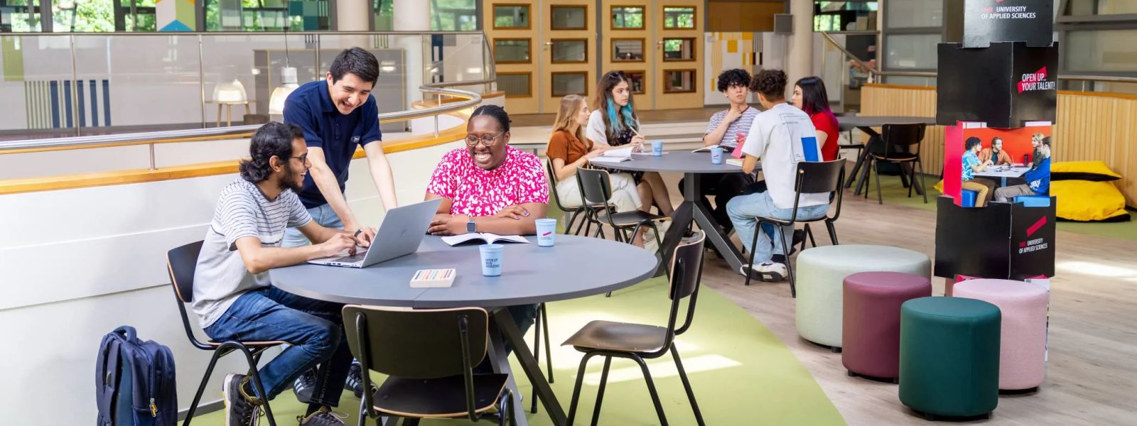Studierende arbeiten gemeinsam an Tischen in einem Lernbereich der HAN University of Applied Sciences