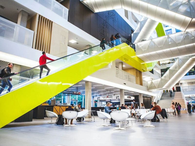 Das Atrium des Gebäudes der Hogeschool Utrecht mit der leuchtend gelben Rolltreppe