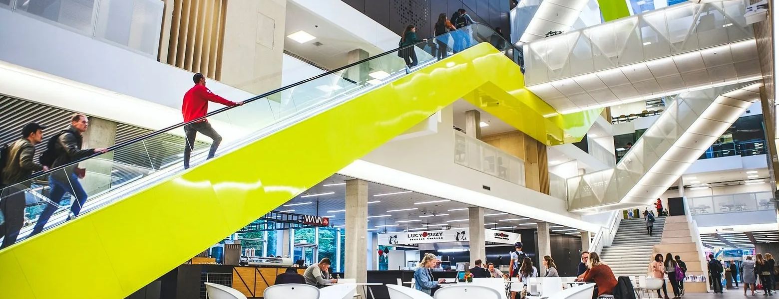 Das Atrium des Gebäudes der Hogeschool Utrecht mit der leuchtend gelben Rolltreppe