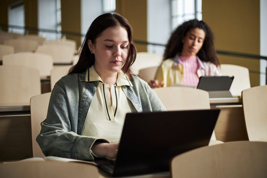 Kandidatinnen und Kandidaten an Laptops in einem Hörsaal