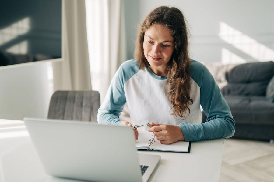 Person, die am Laptop Arbeiten bewertet und Notizen macht