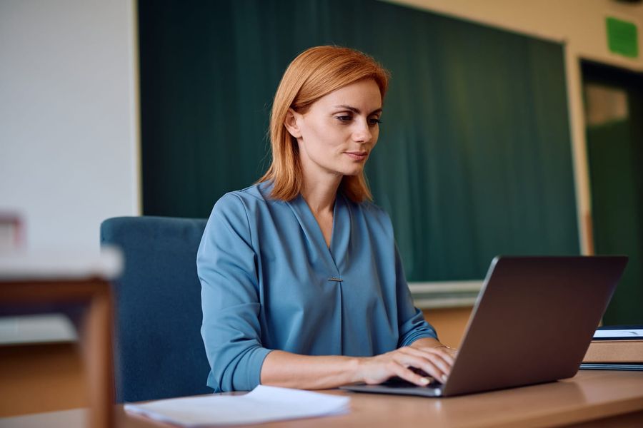 Person, die am Laptop an Prüfungsaufgaben arbeitet