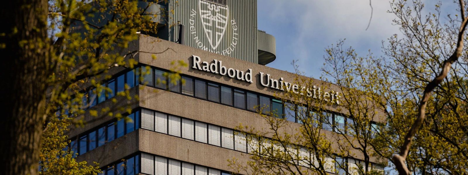 The Radboud Universiteit tower seen through spring foliage